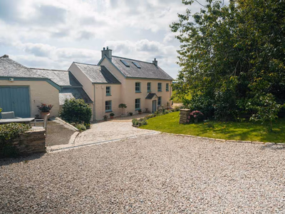 Rear elevation with established gardens and hillside setting