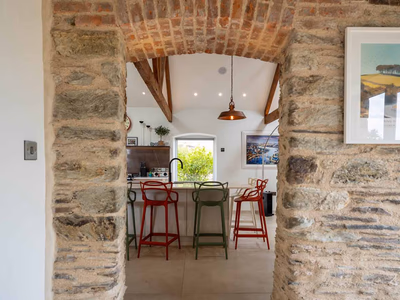 Open-plan barn conversion kitchen with stone pillars