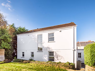 White rendered cottage exterior with established gardens