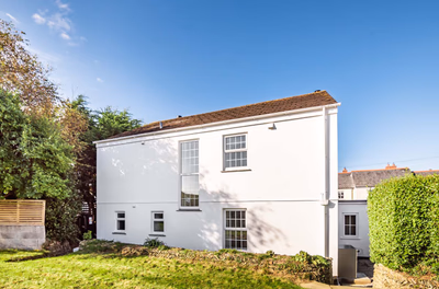 White rendered cottage exterior with established gardens