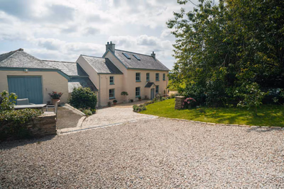 Rear elevation with established gardens and hillside setting