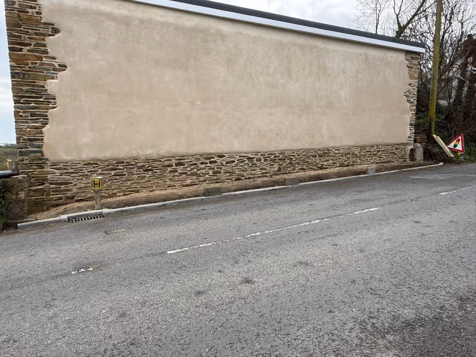 Completed heritage cob wall with natural lime render finish and natural stone corners on a former Cornish post office