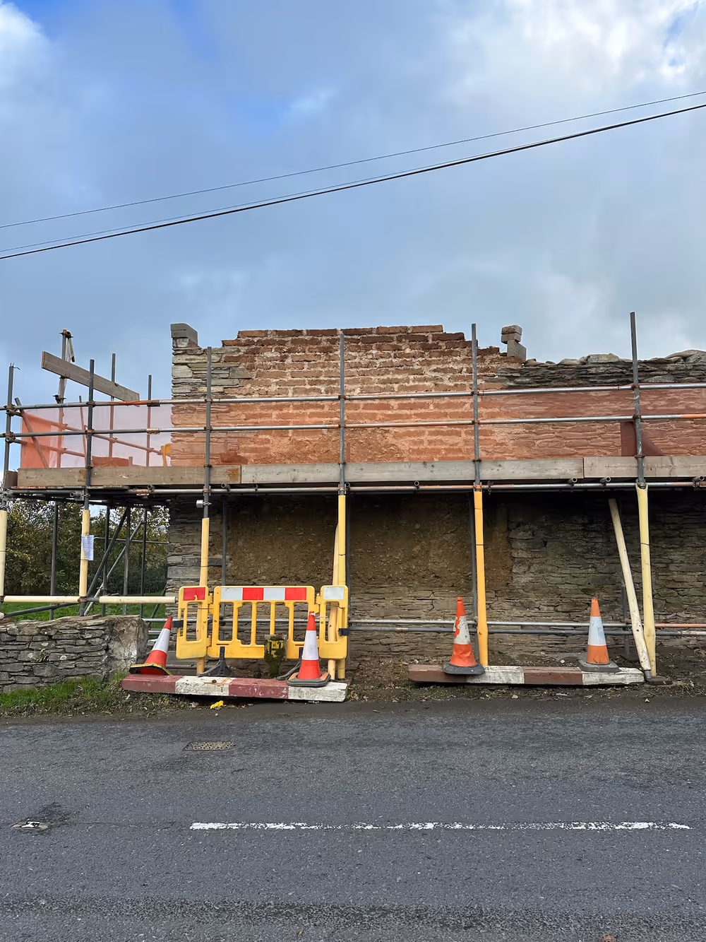 The failing roadside elevation taken down to sound fabric, ready for the rebuild